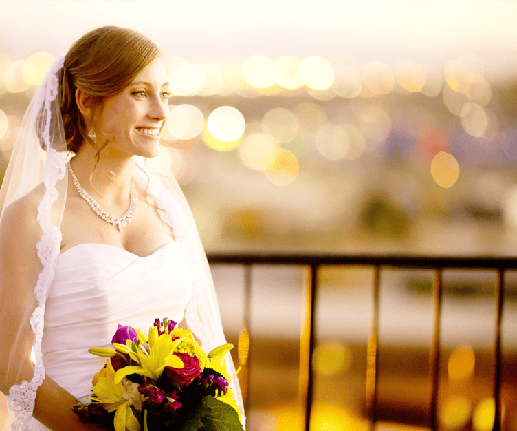 A bride and groom overlooking the Denver city skyline from Brittany Hill