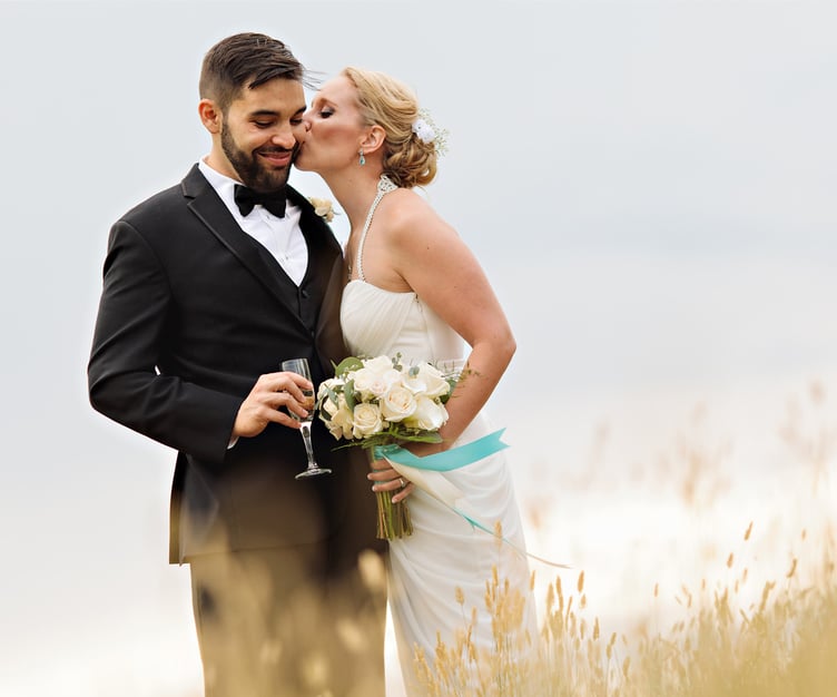 Bride and groom in a field overlooking the mountains during a Denver-area wedding at Ken Caryl Vista