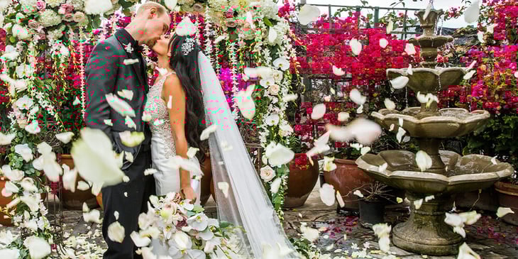 A couple on their wedding day sharing a moment in front of a water fountain at Cuvier Club by Wedgewood Weddings.