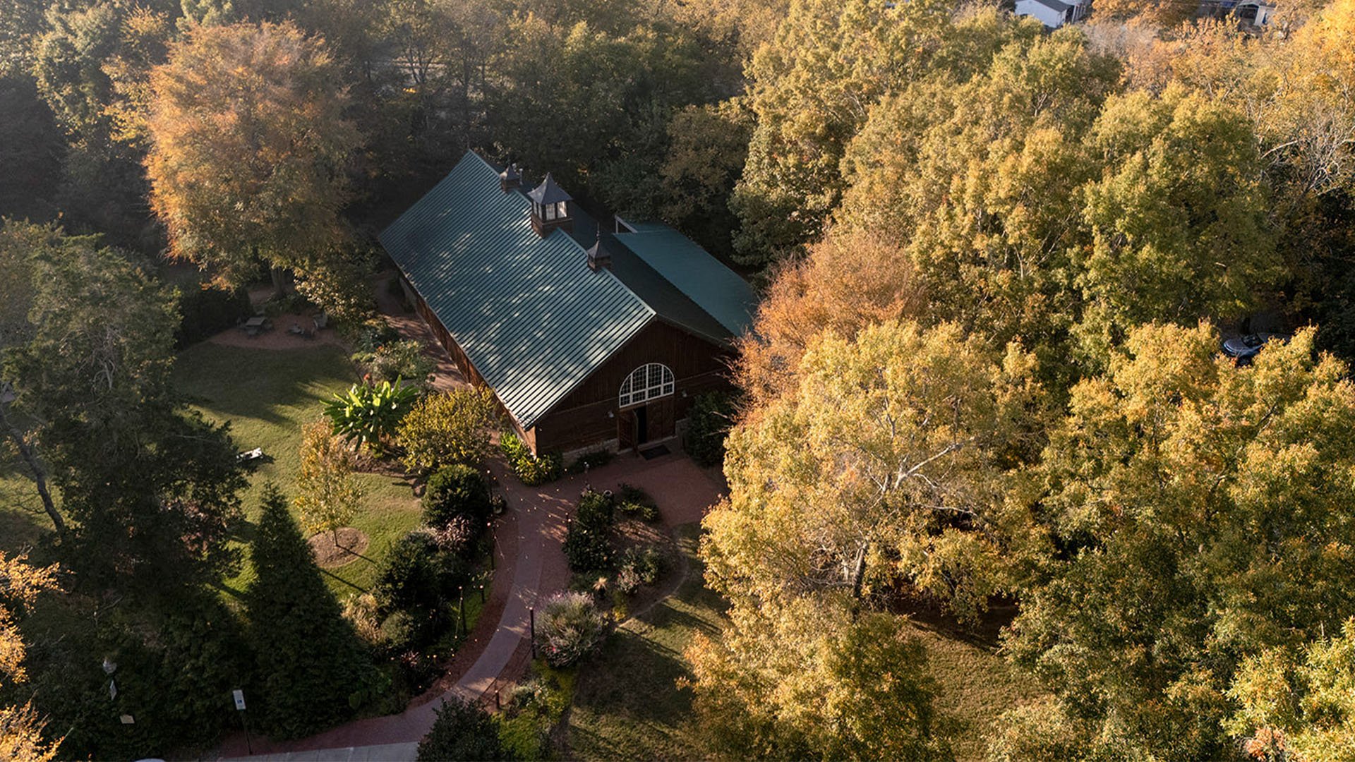 Aerial view of rustic wooden wedding venue nestled among autumn trees in Charlotte NC