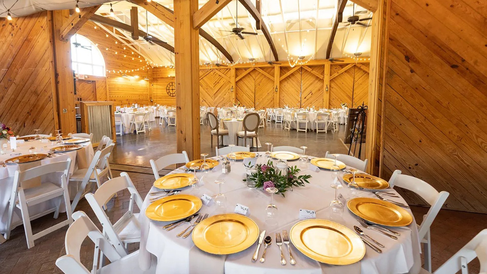 Rustic elegant reception hall with wooden beams, string lights and gold charger plates at Wedgewood Weddings Charlotte NC (2)