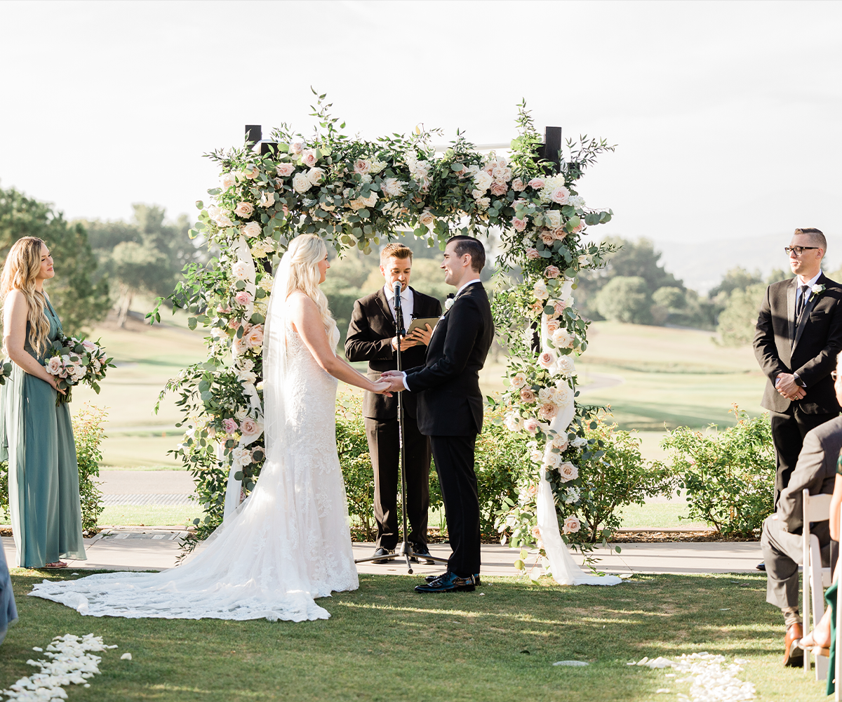 Couple at arbor lawn ceremony with dramatic floral - Aliso Viejo by Wedgewood Weddings