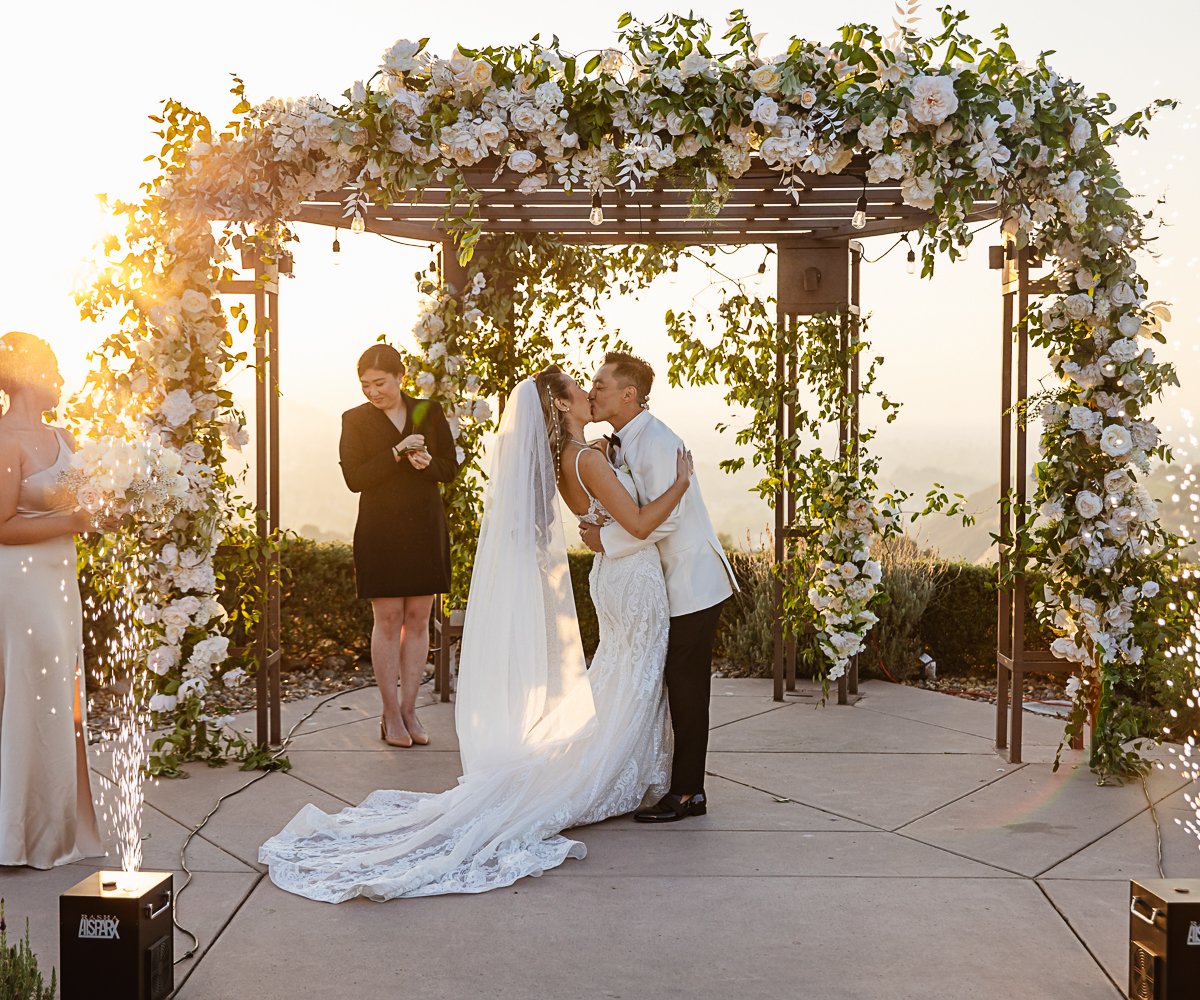 First kiss arch with elaborate flowers - Boulder Ridge by Wedgewood Weddings