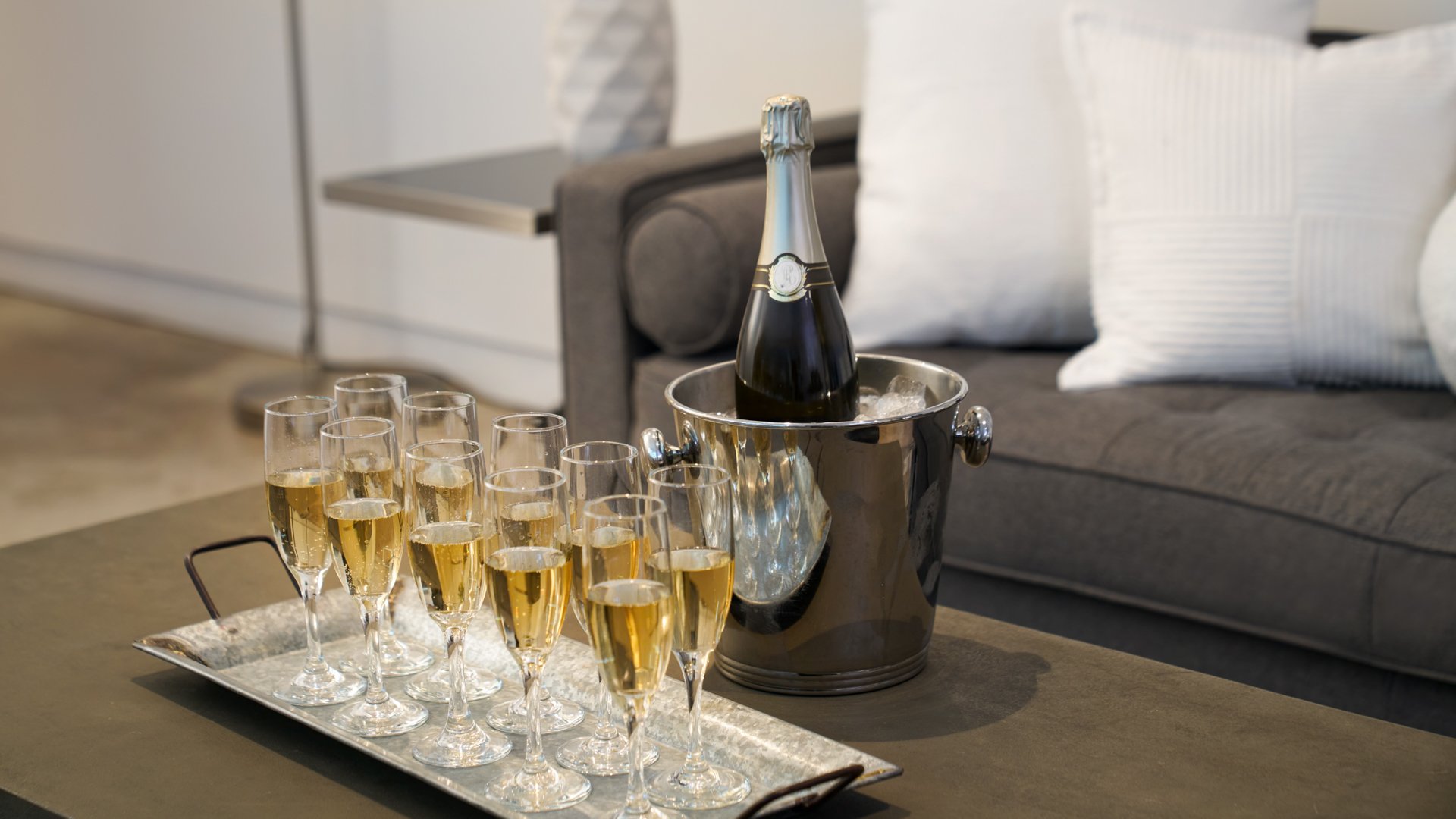 Close-up of champagne glasses and a chilled bottle in a modern wedding suite at The Clayton House in Scottsdale, Arizona, ready for the couple’s pre-ceremony celebration.