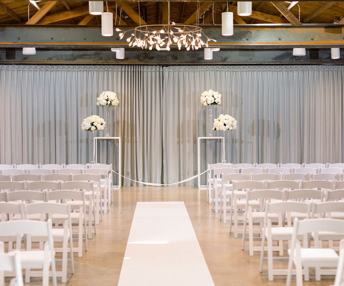 Elegant indoor ceremony with grey drapery at The Rafters at Clayton House by Wedgewood Weddings