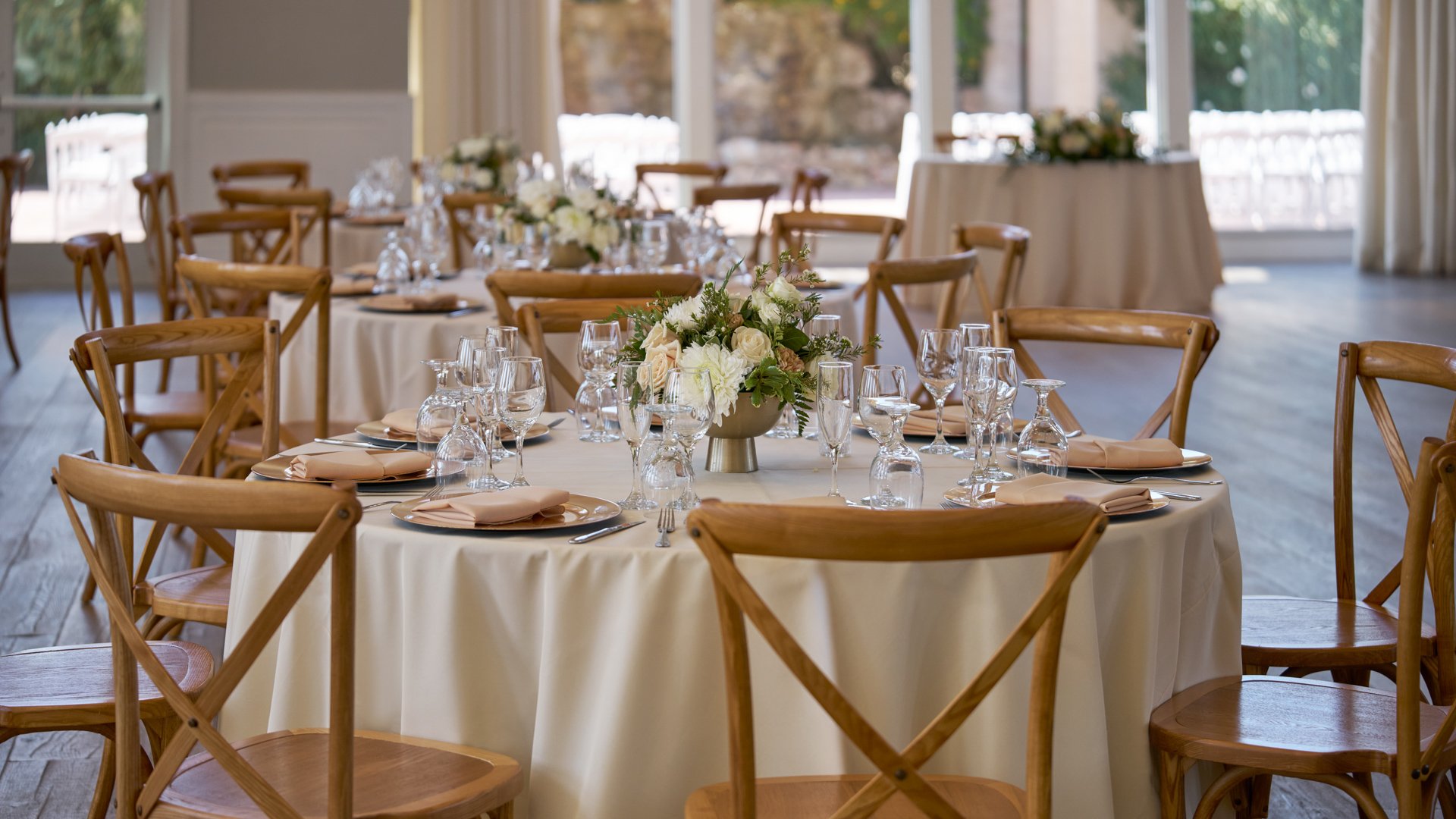 Grand Hall banquet setup at Colby Falls Arizona featuring round tables with floral centerpieces, elegant place settings, and wooden chairs.