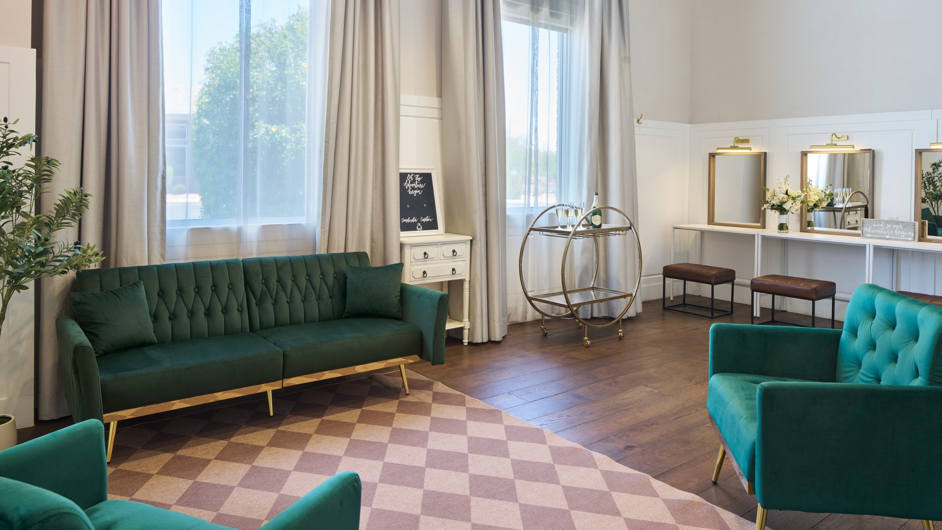 Bridal dressing suite at Colby Falls Arizona with green velvet sofas, vanity mirrors, floral accents, and natural light for wedding preparations.