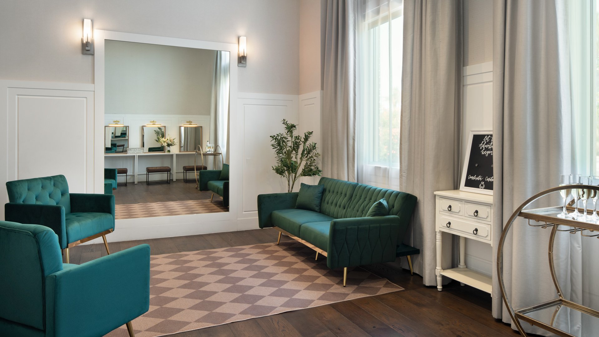 Spacious bridal suite at Colby Falls Arizona featuring modern décor, velvet seating, a large mirror, and vanity stations for wedding prep.