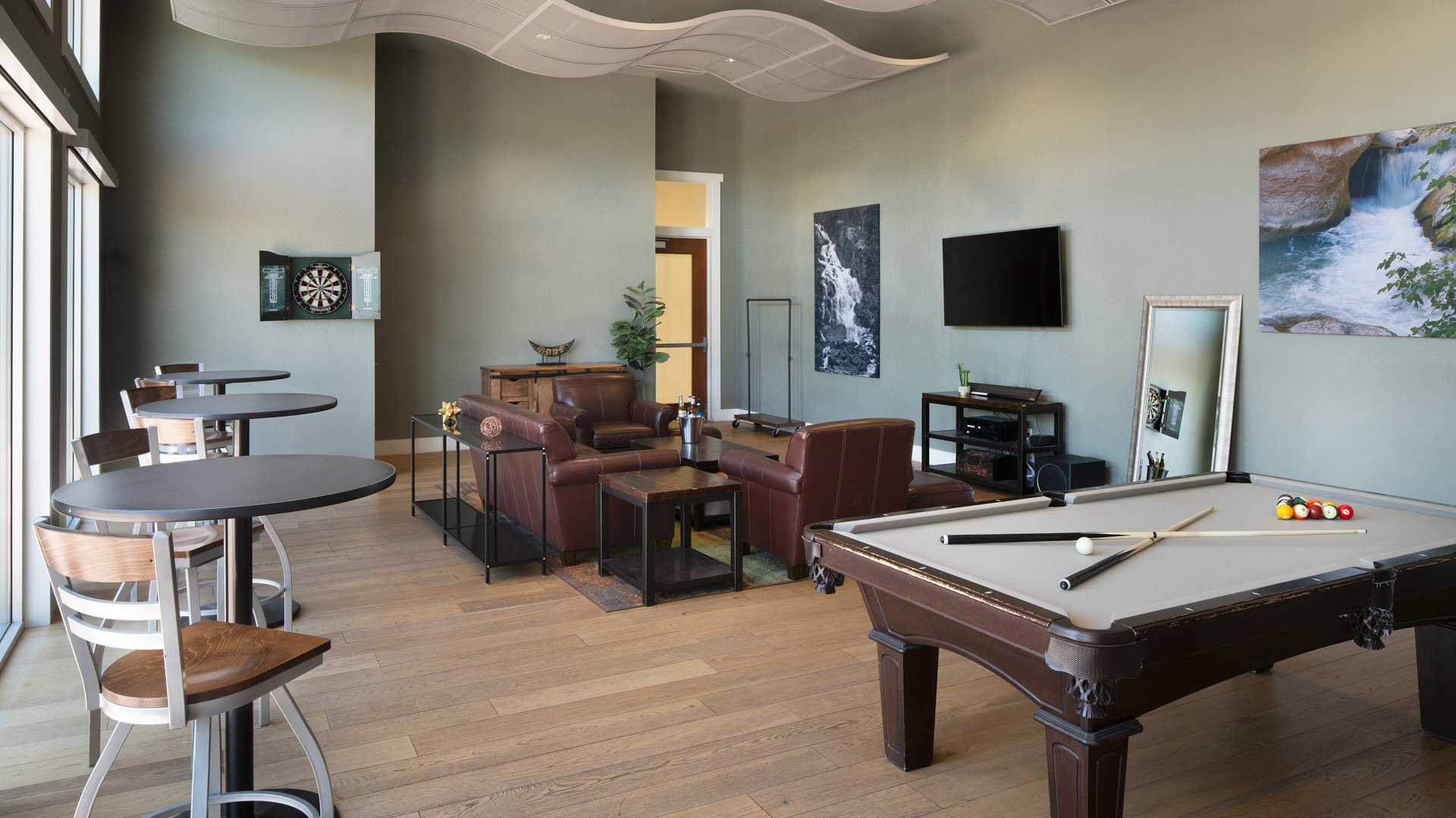 Groom’s game room suite at Colby Falls Arizona with pool table, leather seating, dart board, and lounge-style wedding preparation space.