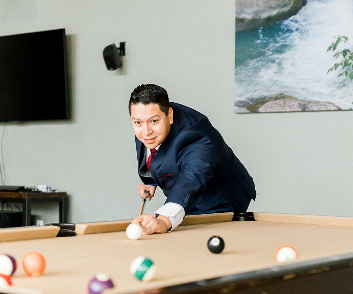 Groomsman playing pool in get ready room - Colby Falls by Wedgewood Weddings