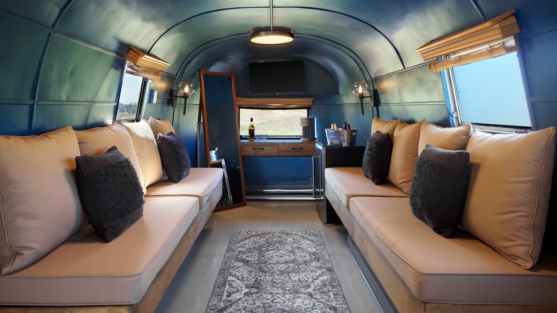 Stylish Airstream Silver Suite at Danza del Sol Winery in Temecula, CA, with lounge seating, vanity, and unique modern décor for wedding preparations.