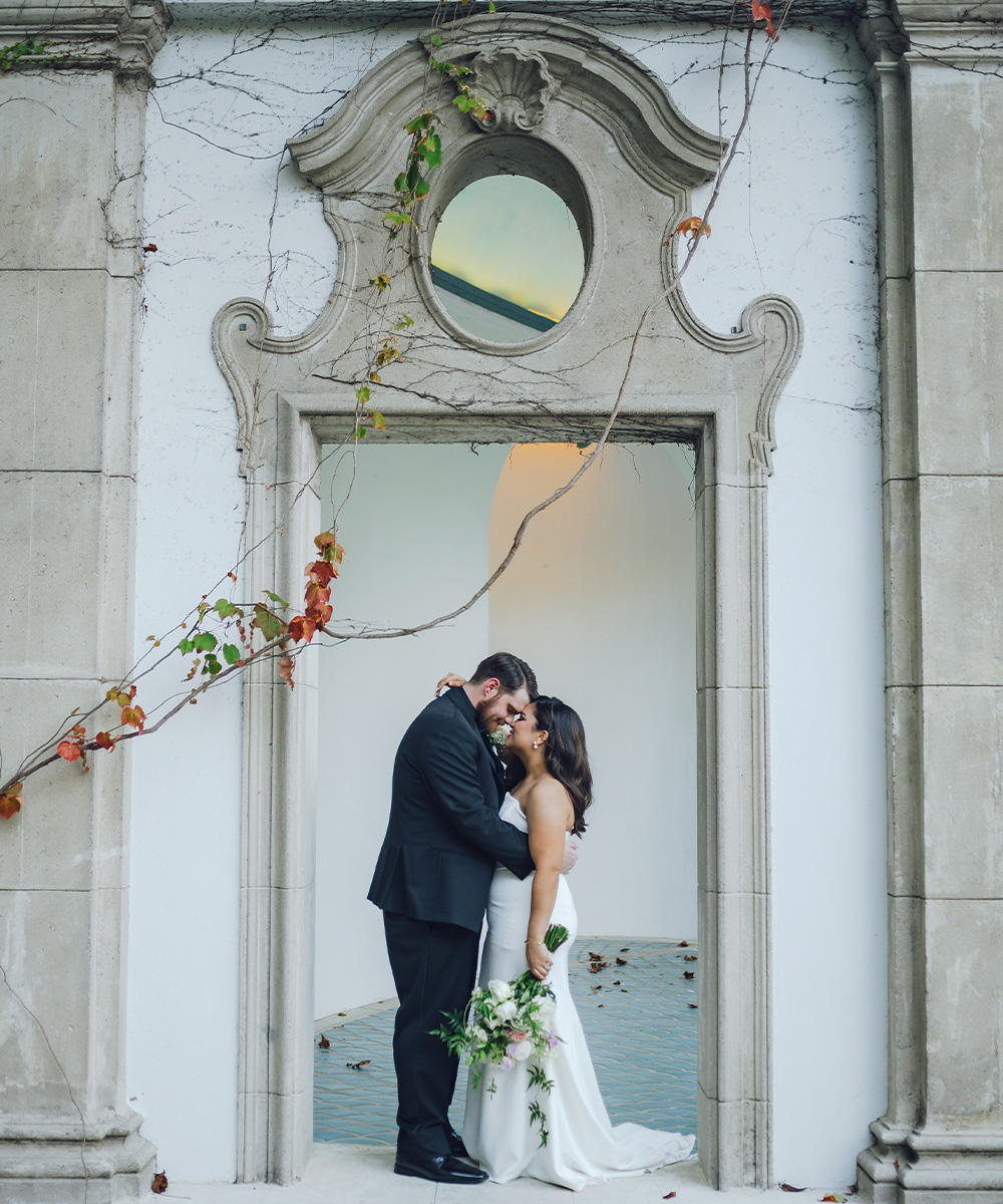 Couple posing in front of columns - Hacienda de las Flores by Wedgewood Weddings