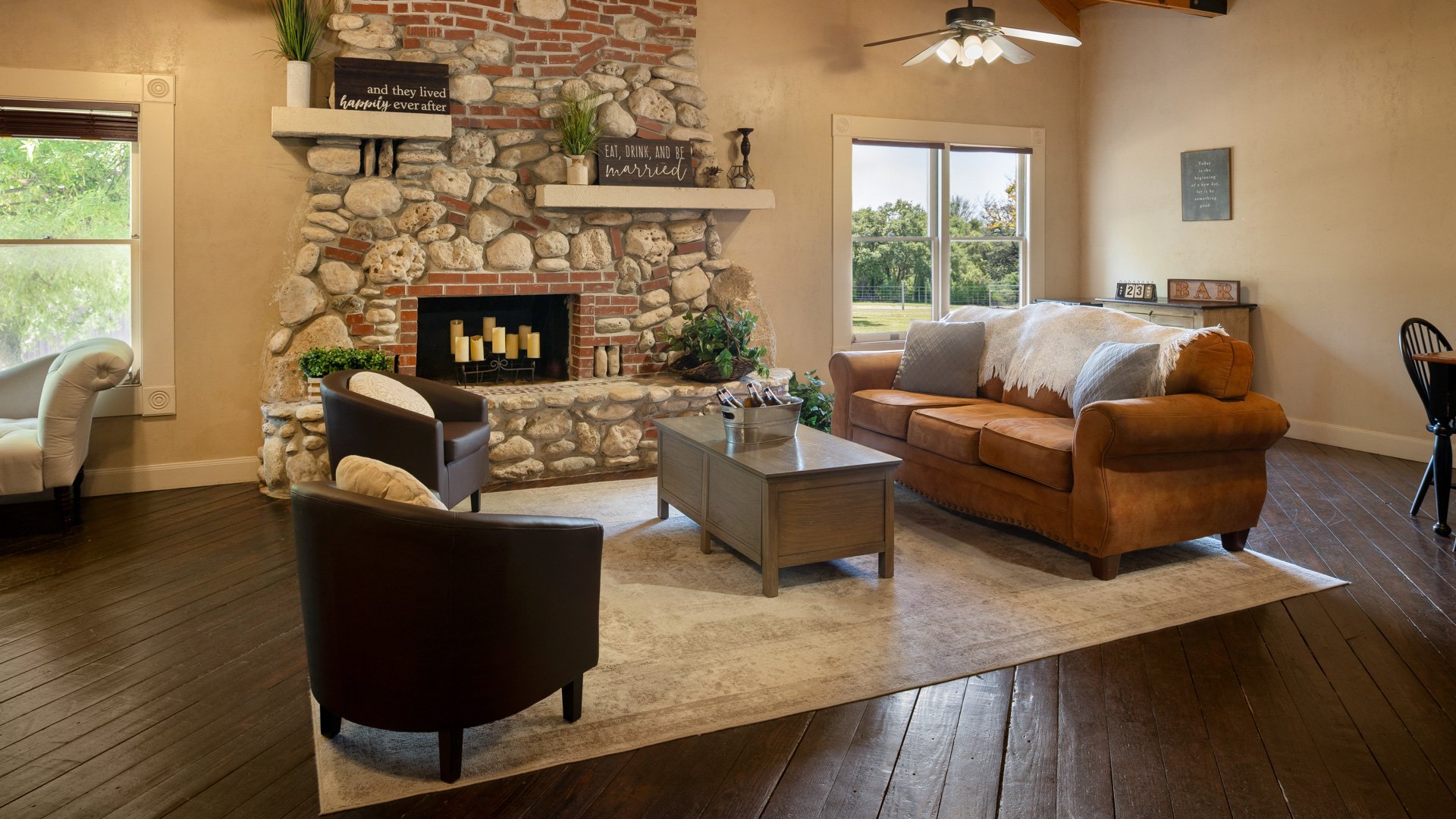 Wedding get ready suite at Hofmann Ranch featuring stone fireplace, leather sofa, and rustic farmhouse décor