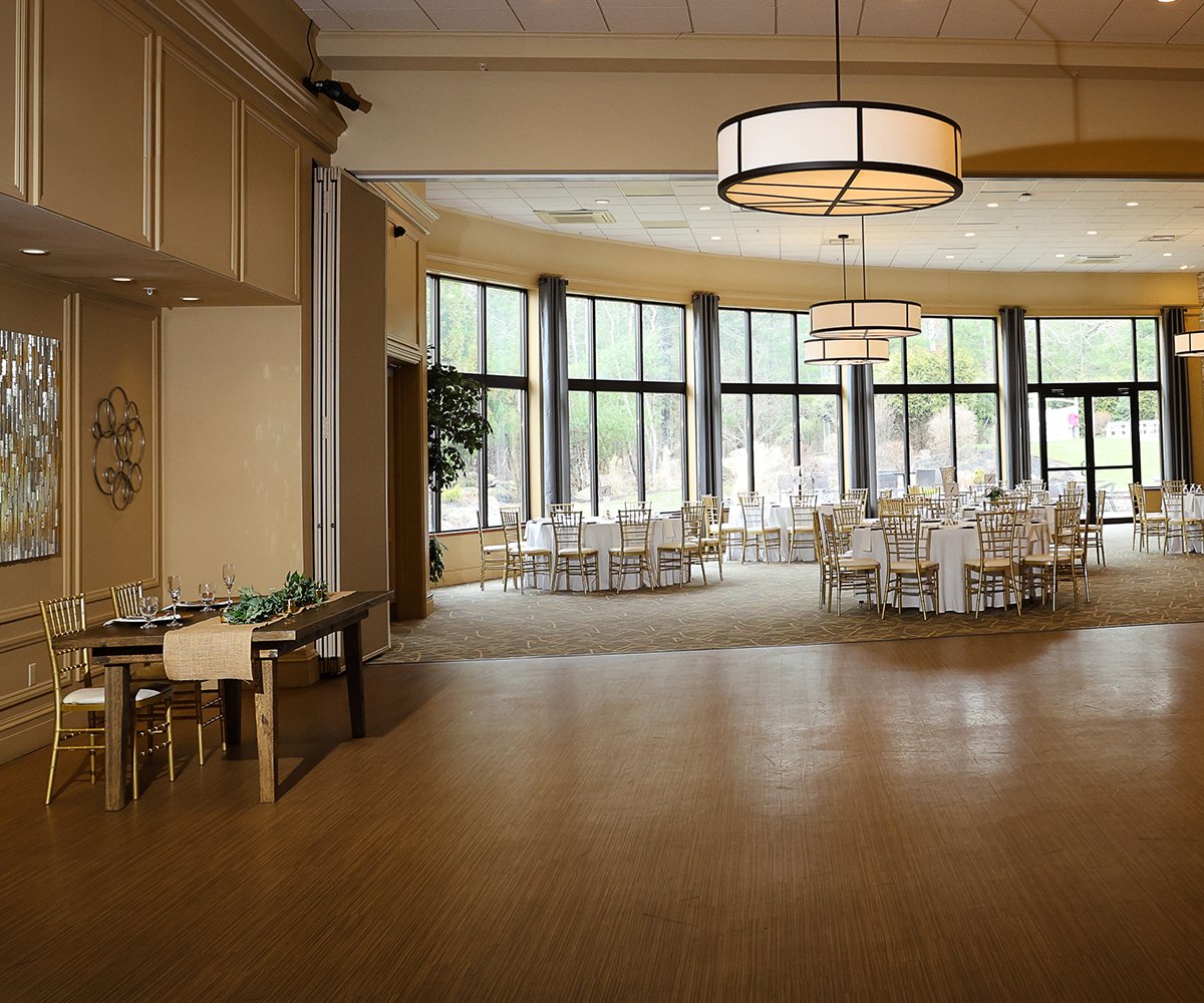 Interior of Miraval Garden's banquet hall with wooden floors and large windows overlooking the garden