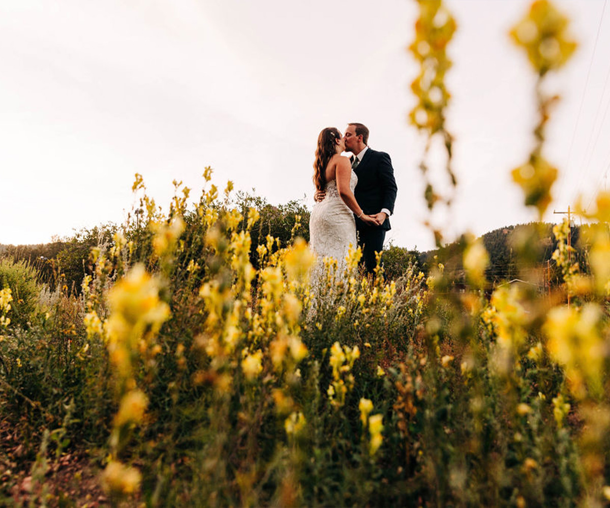 Couple in meadow with flowers at Mountain View Ranch by Wedgewood Weddings