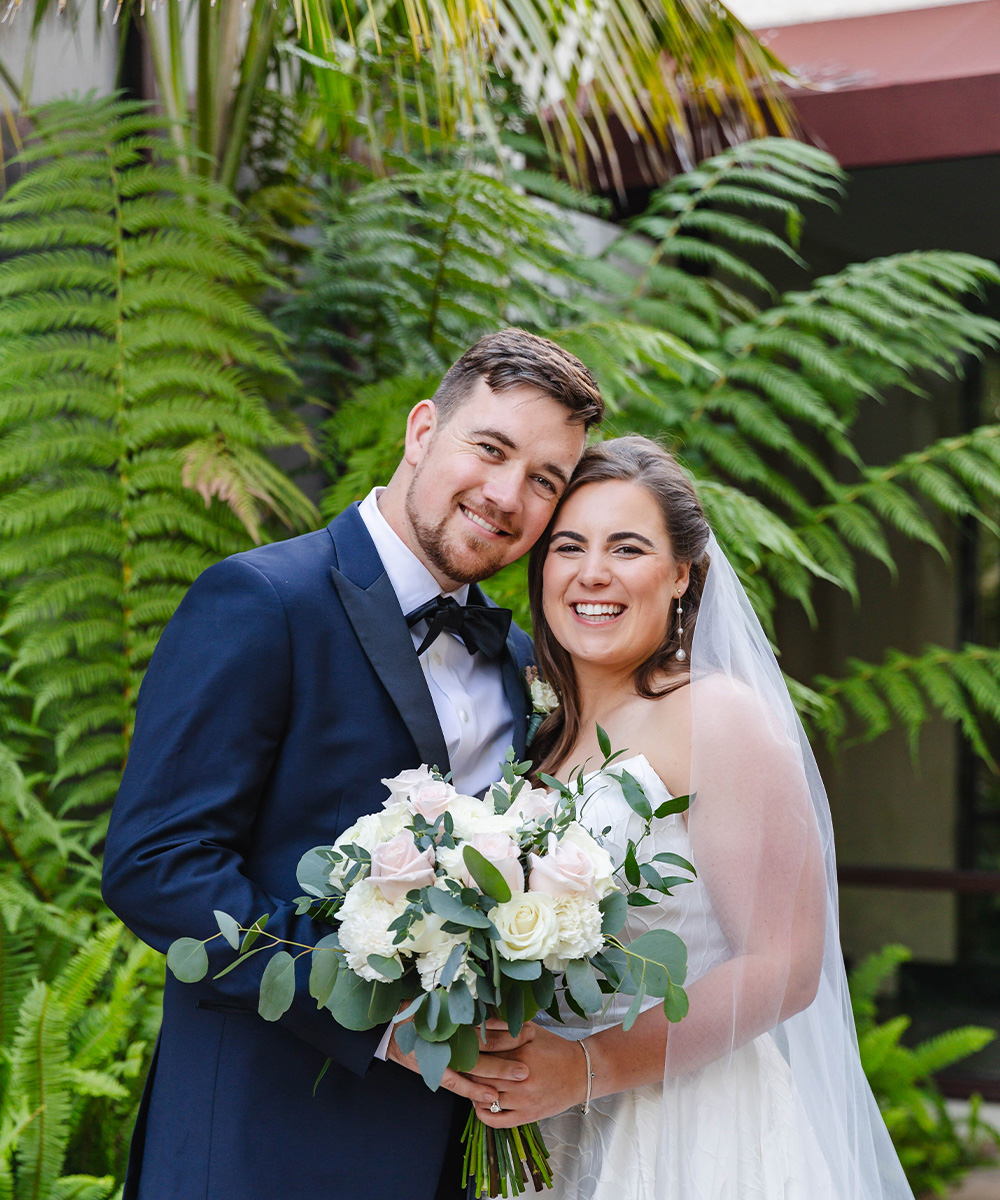 Couple in greenery at Hardie Courtyard - Officers Club by Wedgewood Weddings