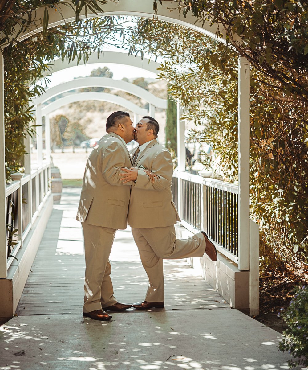 Grooms kissing at bridge photo op - Redwood Canyon by Wedgewood Weddings