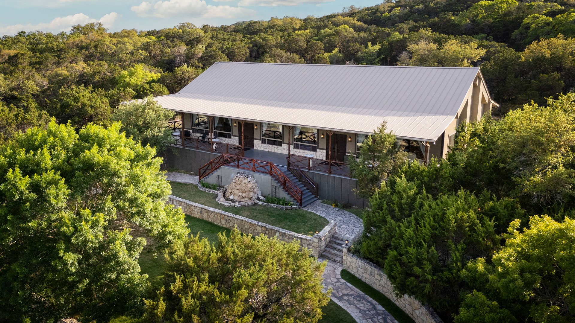 Aerial view of Scenic Springs wedding venue in Helotes, Texas, surrounded by lush green trees and stone walkways.