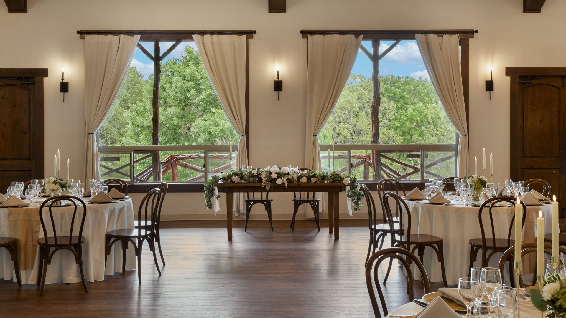 Scenic Springs reception ballroom in Helotes, TX, showcasing a sweetheart table with floral décor and round guest tables.