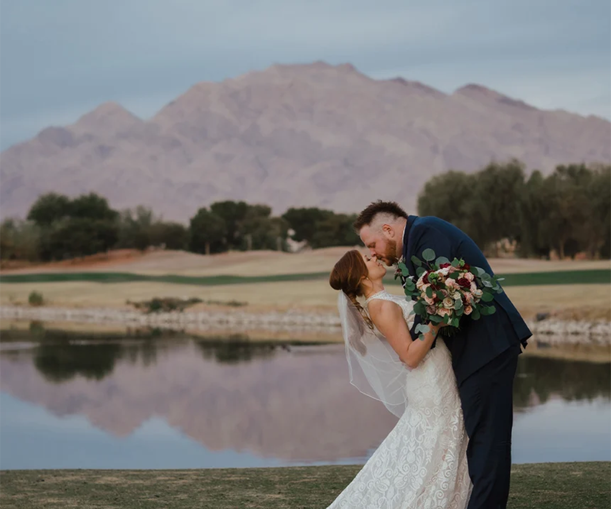 Couple kissing in front of lake with mountain view - Stallion Mountain by Wedgewood Weddings.webp