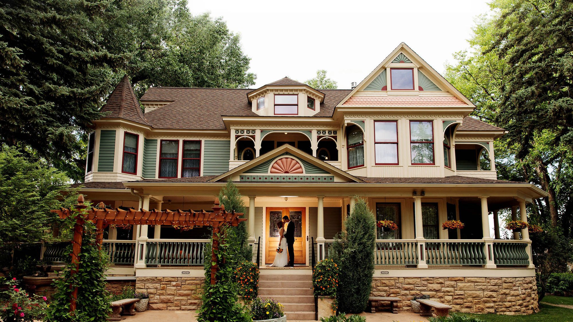 Victorian style estate in Northern Colorado featuring bride and groom kissing on stoop
