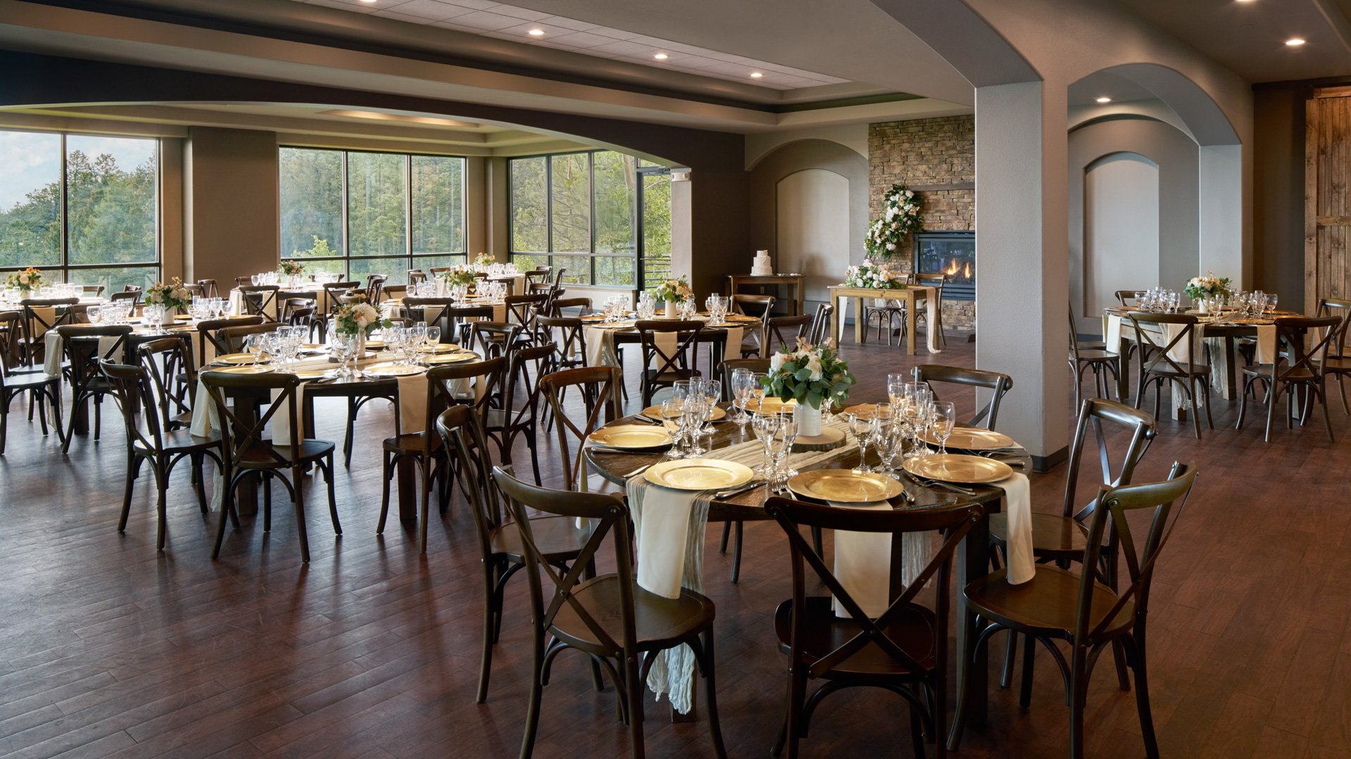 Refined wedding reception setup with gold accents, floral décor, and panoramic forest views at The Pines Upper Level in Colorado.