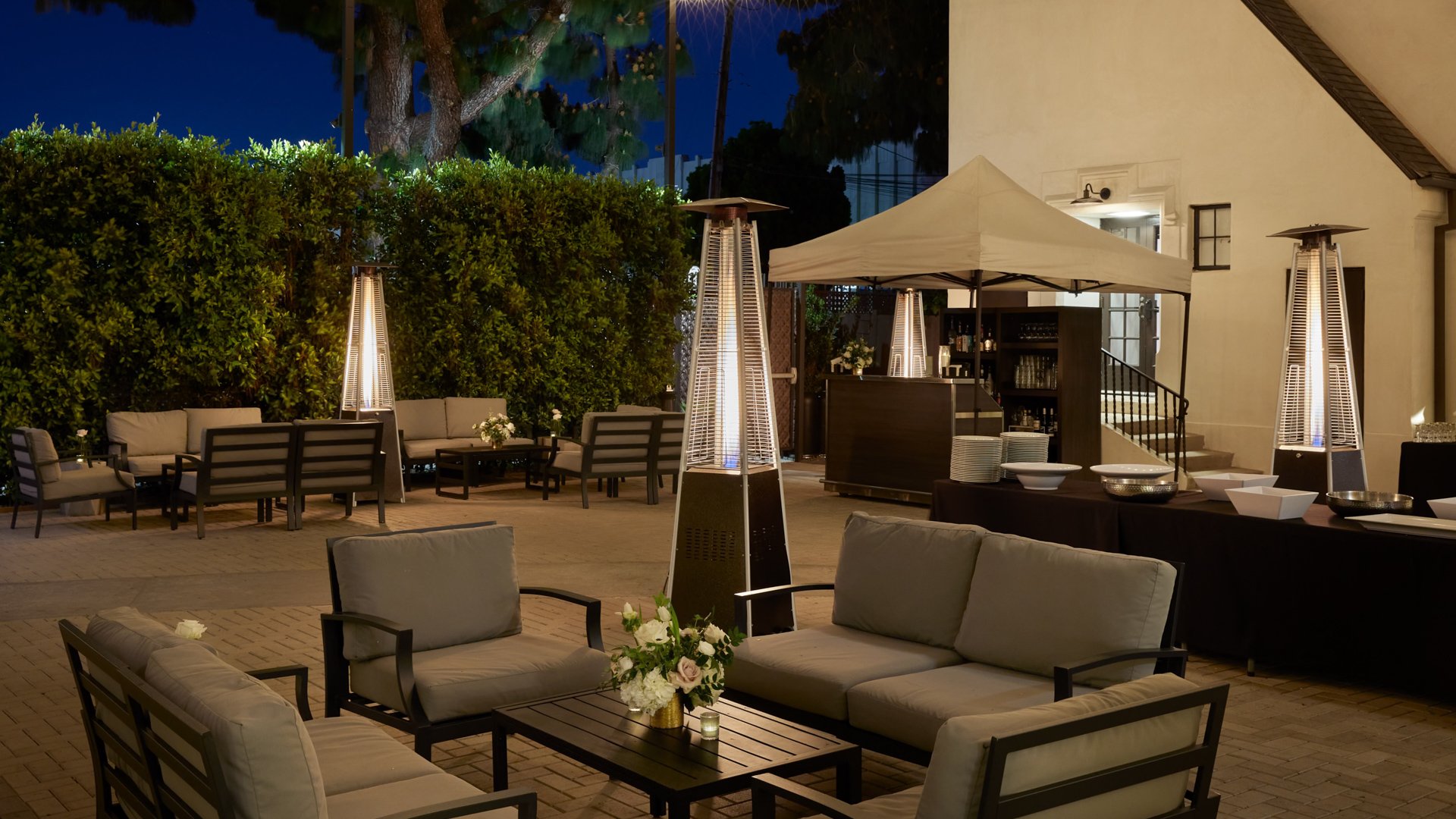 Outdoor courtyard at The Sanctuary in Long Beach with cozy lounge seating, heaters, and wedding cocktail hour setup.