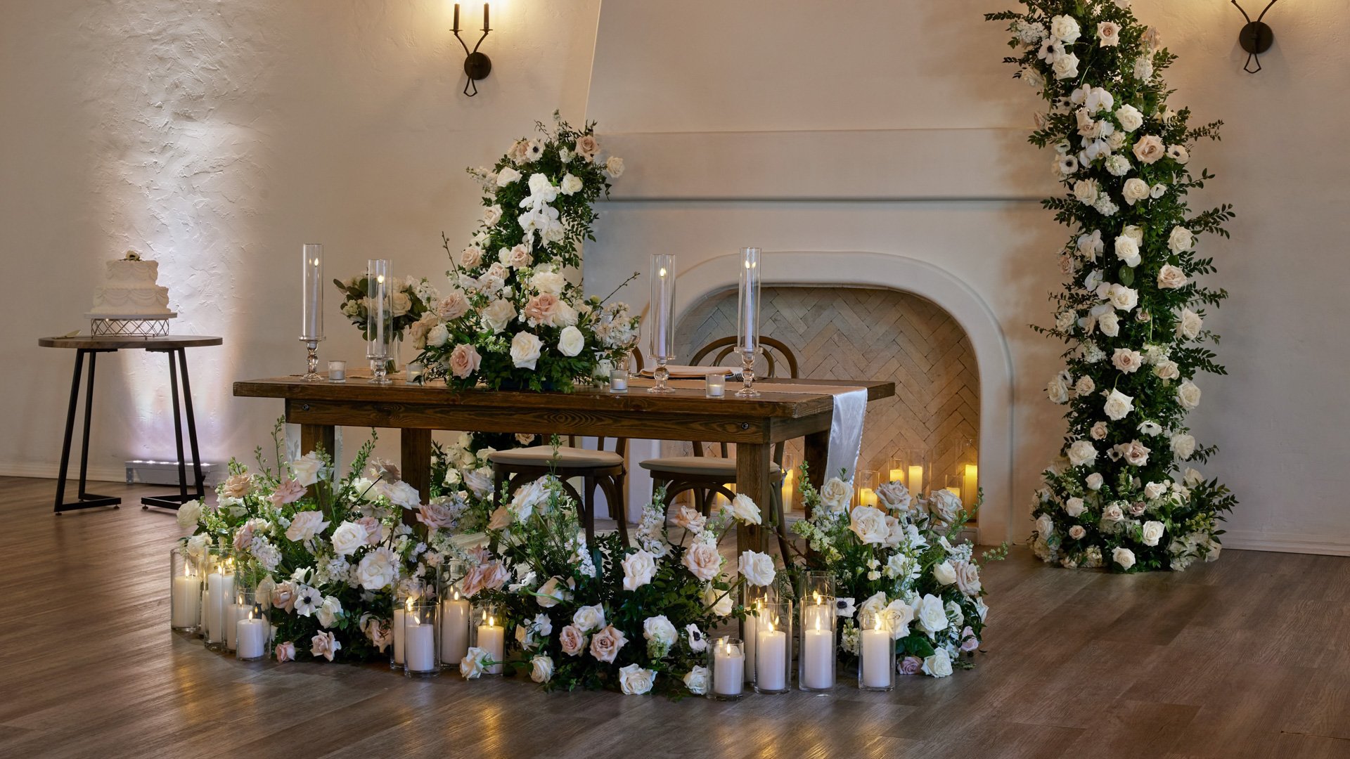 Wedding table place setting in The Sanctuary Grand Hall, Long Beach, with gold charger plates, glassware, and white florals.