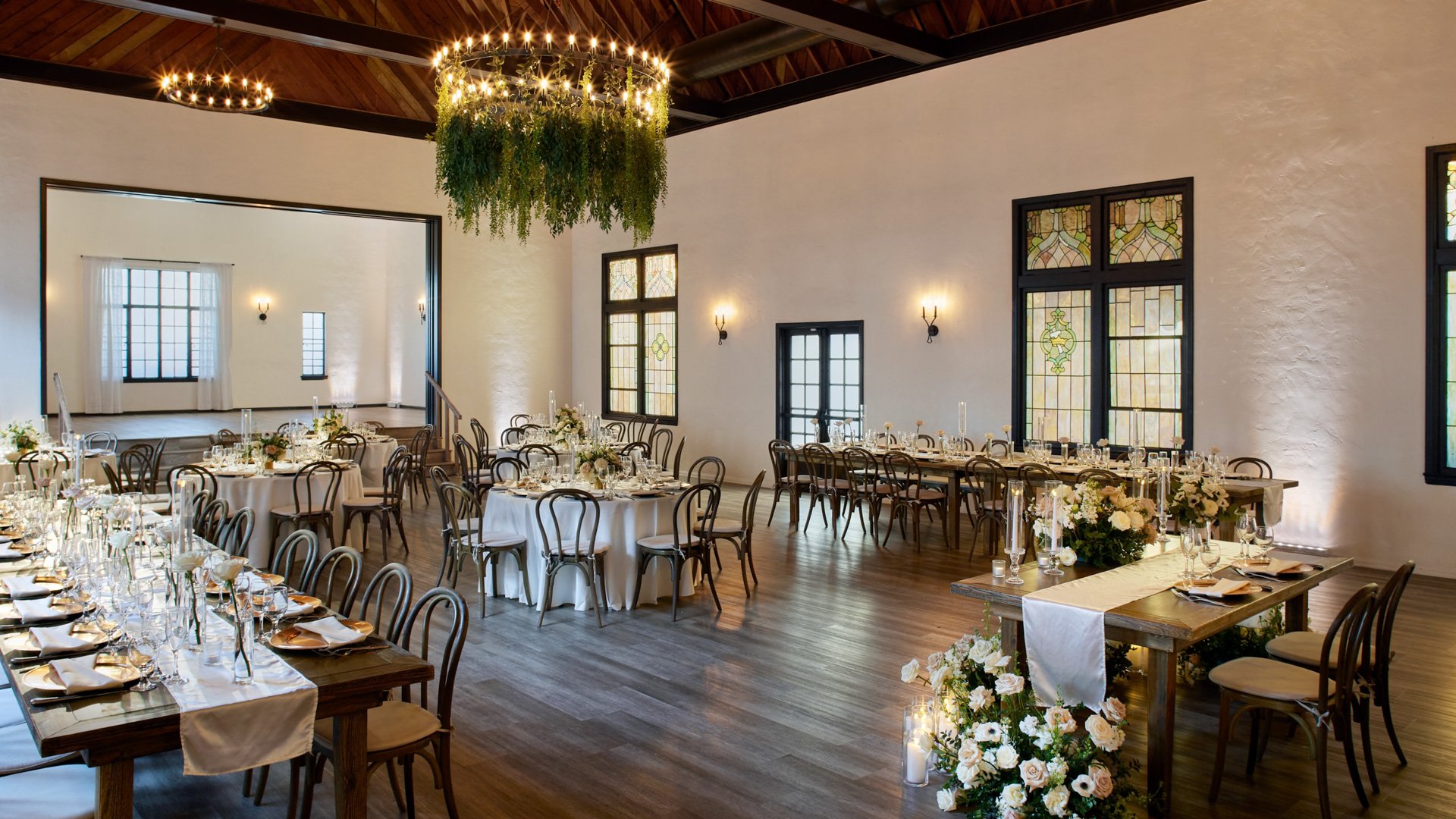 Wedding reception in The Sanctuary’s Grand Hall, Long Beach, with sweetheart table, floral centerpieces, and elegant wood seating.