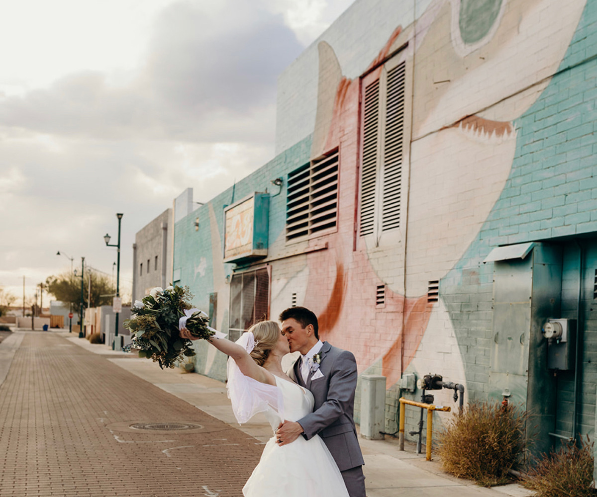 Couple kissing in front of mural - Tre Bella by Wedgewood Weddings
