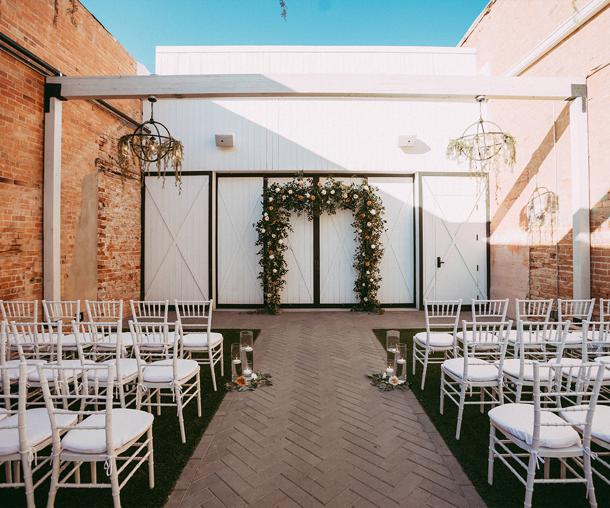 Courtyard ceremony with greenery arch - Tre Bella by Wedgewood Weddings