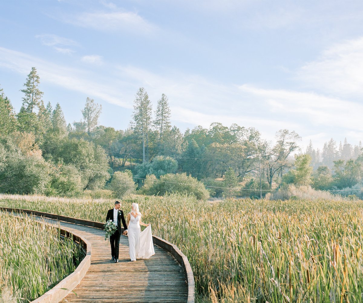 Newlyweds-walking-along-bridge---Winchester-Estate-by-Wedgewood-Weddings