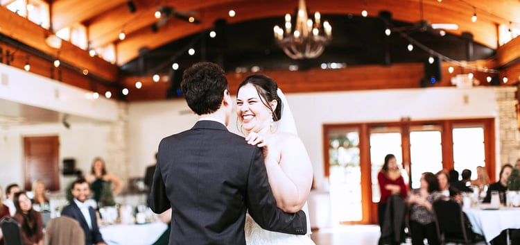 A NEW BRIDE SHARES A FIRST DANCE WITH HER HUSBAND IN THE BALLROOM AT OCOTILLO OASIS