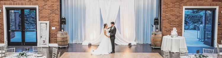 A NEWLYWED COUPLE ENJOY AN INTIMATE MOMENT ALONE IN THE BALLROOM AT EVERGREEN SPRINGS