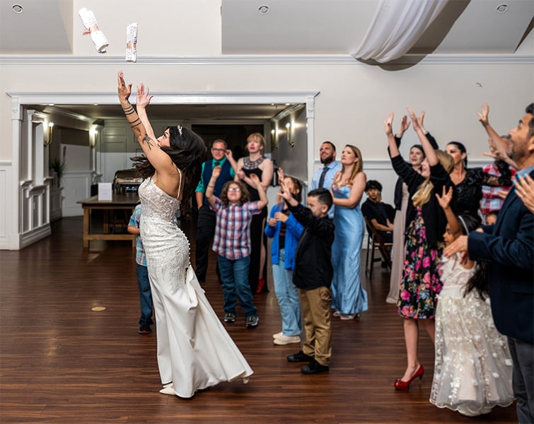 The bride tossing custom wedding-themed t-shirts to excited guests at the reception