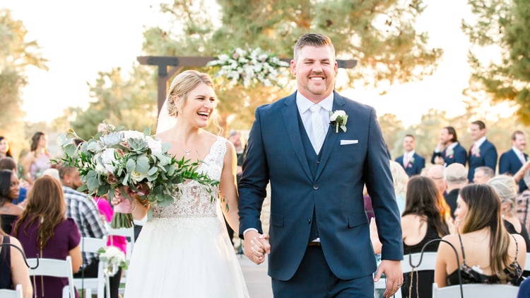 Courtney & Hunter in full jovial smiles as they walk off as newlyweds