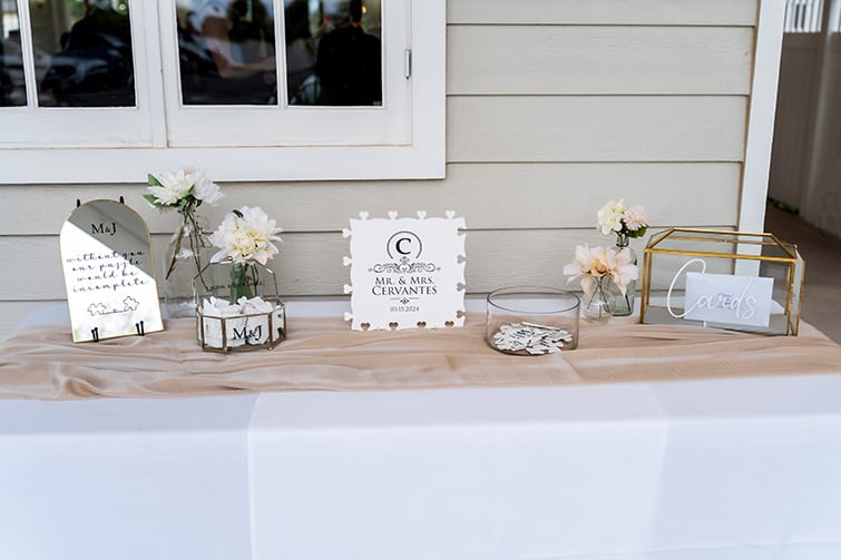 Wedding welcome table with custom signs, cards, and floral arrangements.