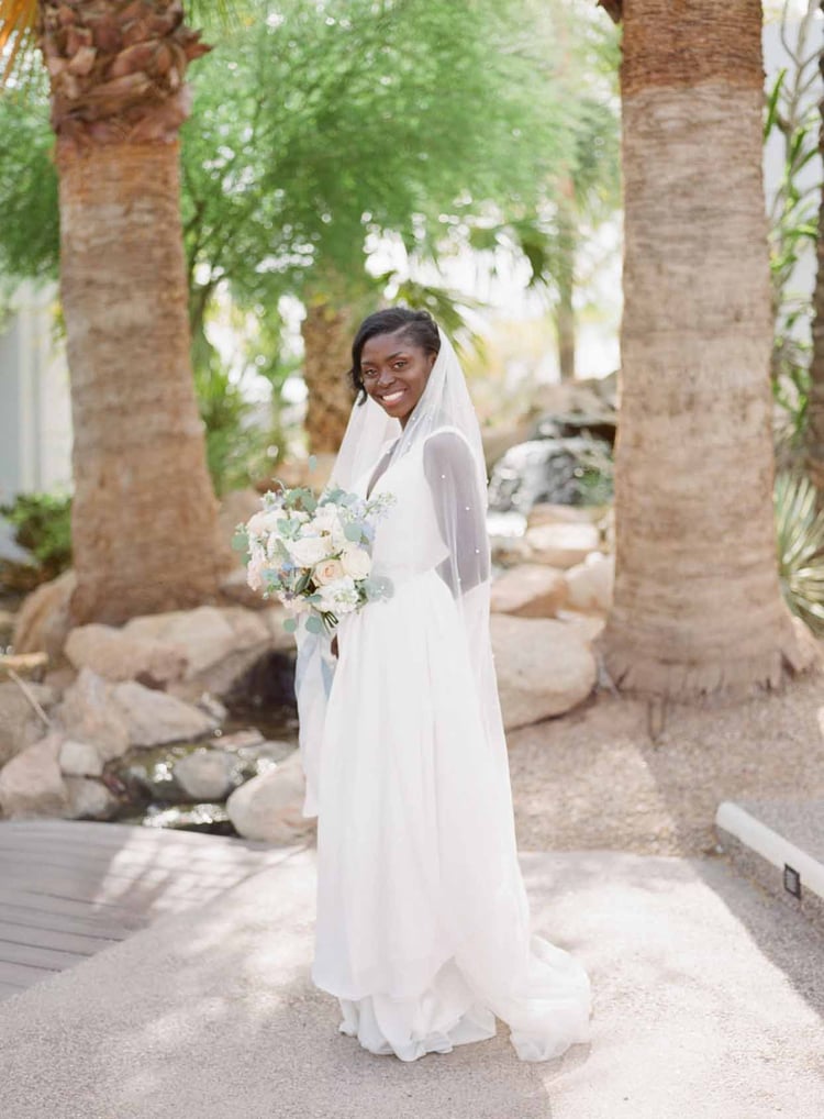 Enyo était magnifique dans une simple robe de mariée blanche avec une ceinture et un voile rehaussés de perles