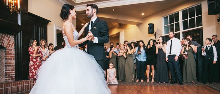 GUESTS WATCH ON WITH ADMIRATION AS THE BRIDE AND GROOM ENJOY THEIR FIRST DANCE AT EAGLE RIDGE