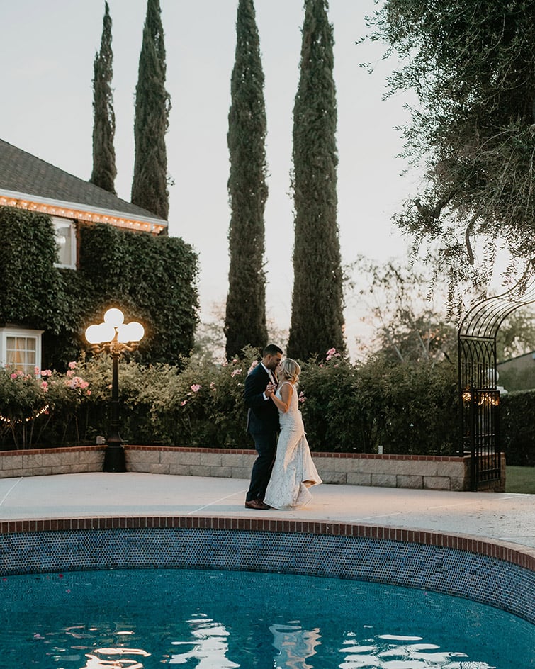 Une première danse romantique au bord de la piscine au coucher du soleil