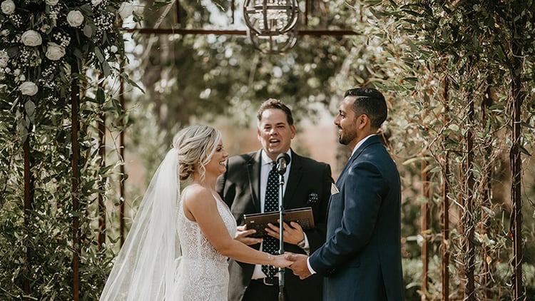 a heartfelt ceremony under the iron arbor decorated with white roses and ivy