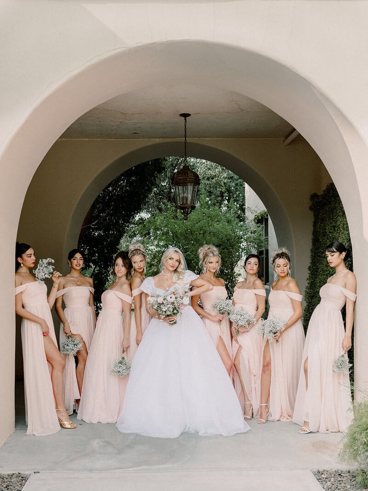 How dashing is this wedding party? The blush-colored gowns perfectly mesh with the black and white tuxedos and coordinating pink socks.