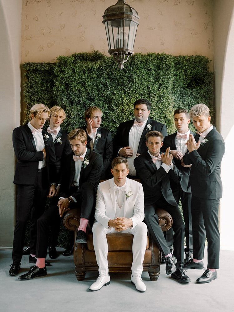 How dashing is this wedding party? The blush-colored gowns perfectly mesh with the black and white tuxedos and coordinating pink socks.