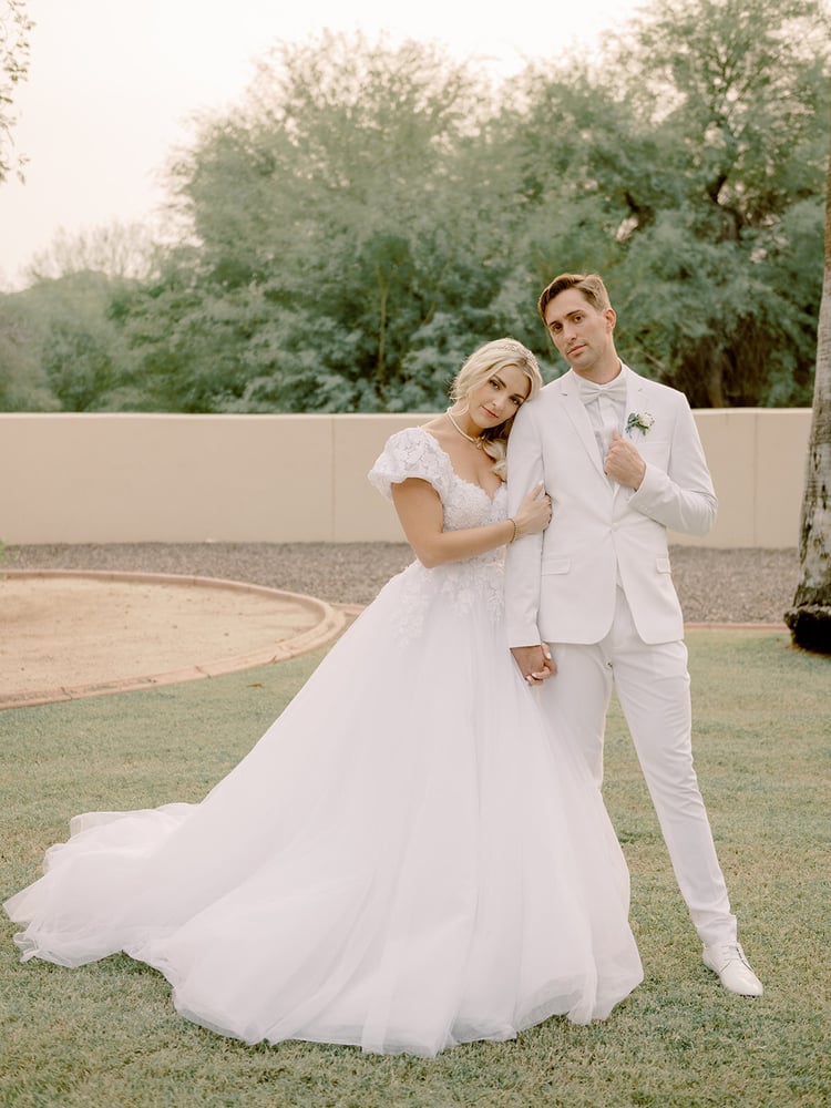 This fashion-forward couple opted for a white-on-white ensemble from head to toe, with the exception of their pastel-colored florals. The star of the [fashion] show was definitely Rydel's custom-made Adriana Papell dress. She wanted to put a modern twist on popular 1980's styles with puffy sleeves, a full skirt, a modern lace bodice, and a playful heart cutout in the back.