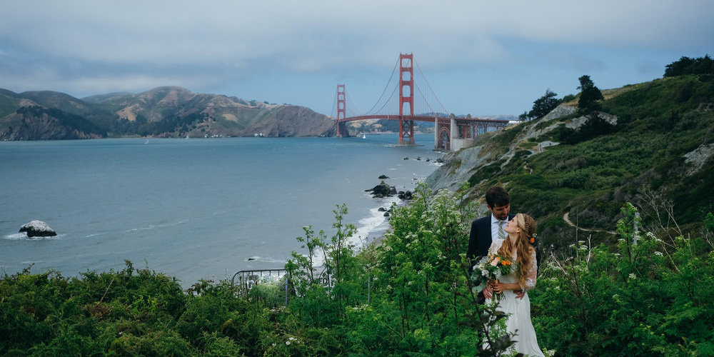 Couple posing with Golden Gate Bridge in the background