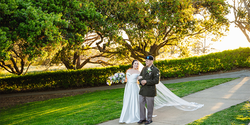 Couple walking down path with large trees at Carmel Fields by Wedgewood Weddings
