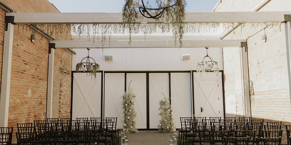 Courtyard ceremony with greenery and baby's breath - Tre Bella by Wedgewood Weddings