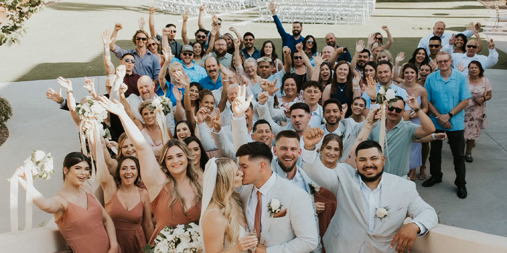 Group shot of couple kissing with guests at Secret Garden by Wedgewood Weddings