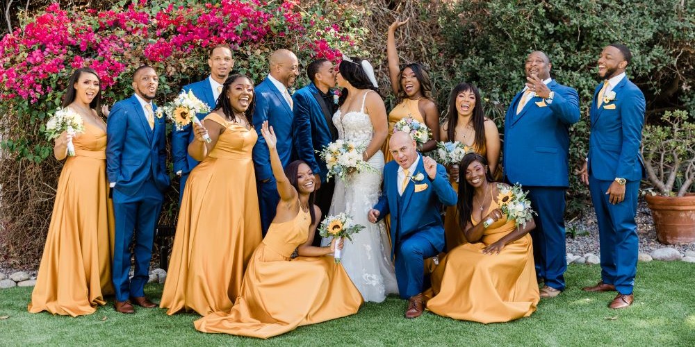 A colorful wedding party poses in front of bougainvillea blossoms at San Clemente Shore, Orange County