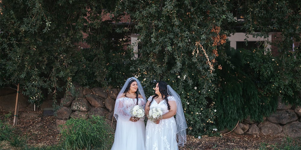 Two brides among greenery at Evergreen Springs by Wedgewood Weddings